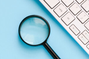 Moderation is like a magnifying glass laying beside computer keyboard on blue table